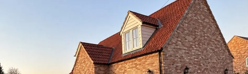 Dormer windows and brick gable on the completed house