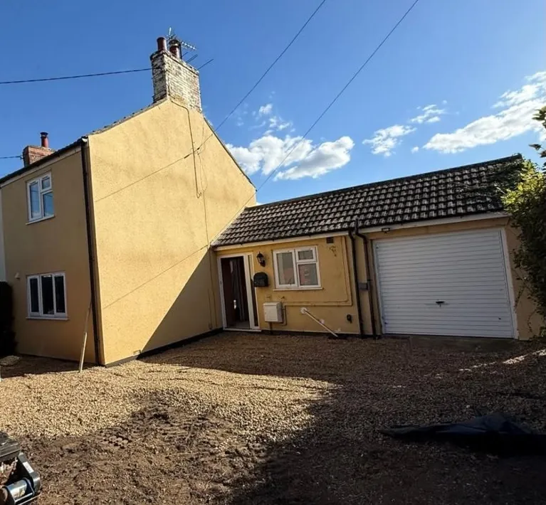 Prepared ground beside the house and garage before the driveway was finished